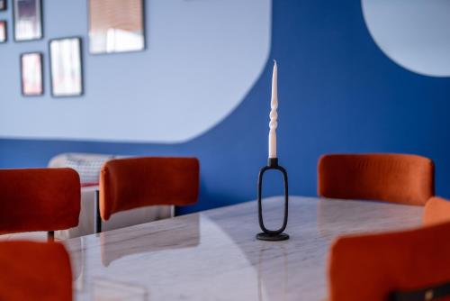a table with orange chairs and a lamp on it at The lodge Residence by Goodmove - Hay Riad in Rabat