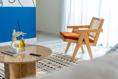 a wooden chair and a table in a room at The lodge Residence by Goodmove - Hay Riad in Rabat
