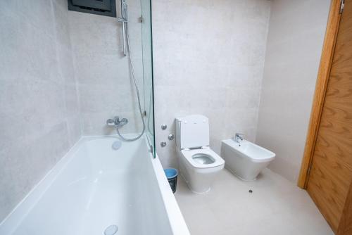 a white bathroom with a toilet and a shower at The lodge Residence by Goodmove - Hay Riad in Rabat