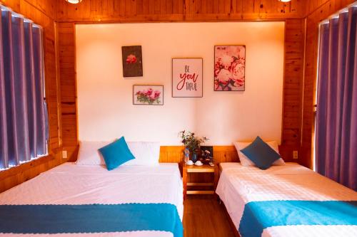 two beds in a room with two windows at Rosa Garden in Ninh Binh