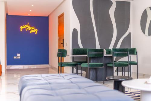 a waiting room with green chairs and a blue wall at The lodge Residence by Goodmove - Hay Riad in Rabat