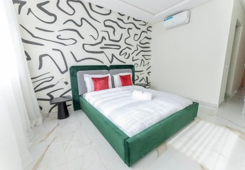 a bedroom with a green bed and a black and white wall at The lodge Residence by Goodmove - Hay Riad in Rabat