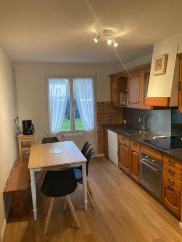 - une cuisine avec une table, une table et des chaises dans l'établissement Maison non fumeur - jardin 5 personnes proche des plages finistériennes, à Guipavas