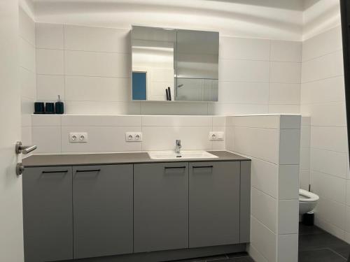 a white bathroom with a sink and a mirror at Apartment Elena in Hinterstoder