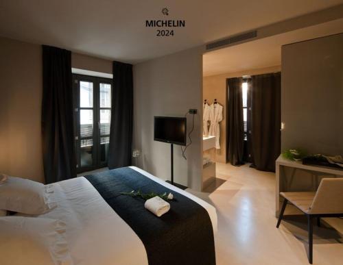 a hotel room with a large bed and a television at Caro Hotel in Valencia
