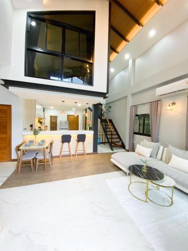 a living room with a couch and a table at Ploy Mountain View Pool Villa in Ban Thai Thai