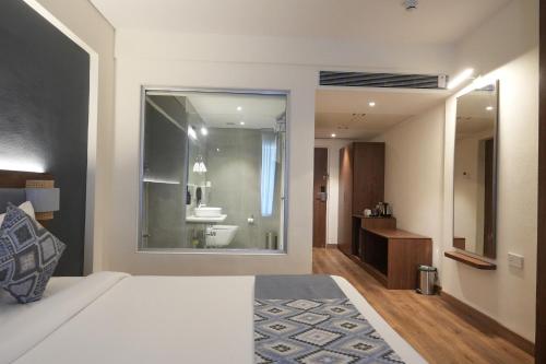 a bedroom with a bed and a bathroom with a sink at Ikshana Resort and Spa, Khandala in Lonavala