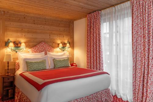 a bedroom with a large bed and a window at Hôtel Saint-Georges in Megève