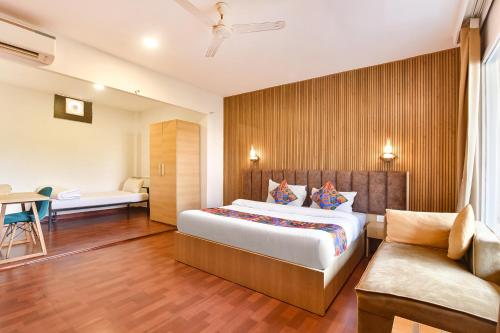 a hotel room with a bed and a couch at FabHotel Morjim Bliss in Morjim