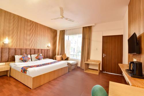 una camera d'albergo con un letto e una televisione di FabHotel Morjim Bliss - 500M From Morjim Beach a Morjim