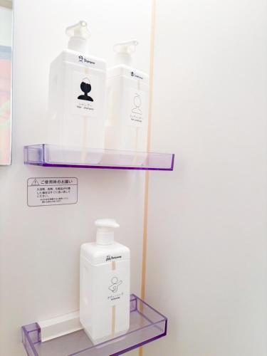 a shelf with two bottles of soap and a detergent at LEON RESORT HOTEL B 4rooms MAX14people 6min Shinjuku 11min Shibuya 12min walk Ikebukuro LEON RESORT IKEBUKURO traditional Japanese room 池袋 最大14名 in Tokyo