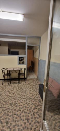 - une chambre avec une table et un banc dans l'établissement Studio IRIS type T1, à Évaux-les-Bains