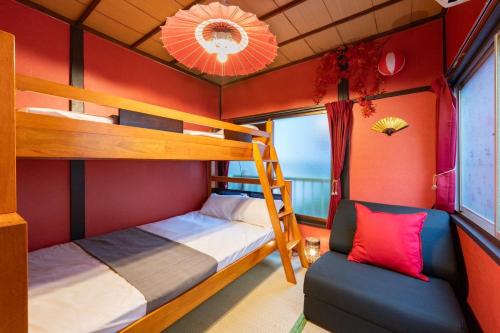 two bunk beds in a room with red walls at LEON RESORT HOTEL B 4rooms MAX14people 6min Shinjuku 11min Shibuya 12min walk Ikebukuro LEON RESORT IKEBUKURO traditional Japanese room 池袋 最大14名 in Tokyo
