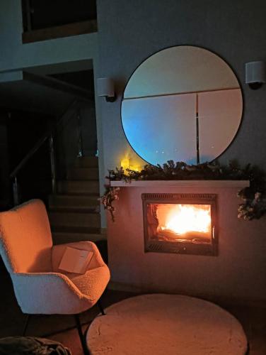 a chair in front of a fireplace with a mirror at Casa Buena Vista in Candás