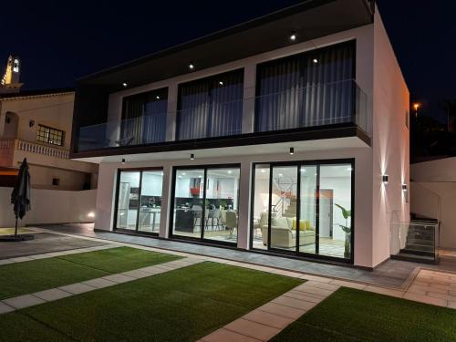 a house with large glass doors and a lawn at Bela Vista Funchal Villa in Funchal