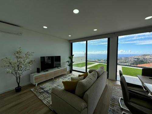 a living room with a couch and a television at Bela Vista Funchal Villa in Funchal