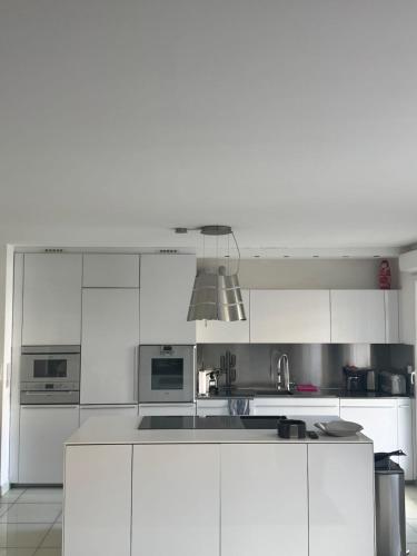 une cuisine blanche avec des armoires blanches et un évier dans l'établissement Luxury apartment, à Marseille