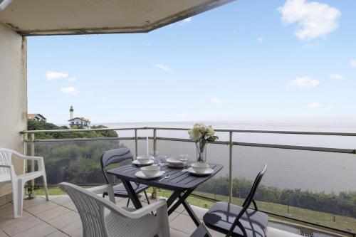 une table et des chaises sur un balcon avec vue sur l'océan dans l'établissement Studio Croskey - Welkeys, à Biarritz
