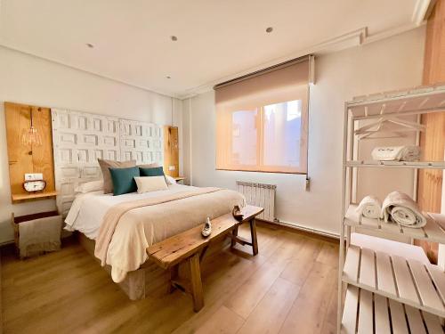 Un dormitorio con una cama grande y una mesa. en Lindo pisito, en León