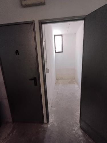 an empty hallway with a door and a window at Fiore in Pieve Di Ledro