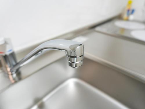 a kitchen sink with a silver faucet at OUCHI HOTEL Onaganishi in Hiroshima