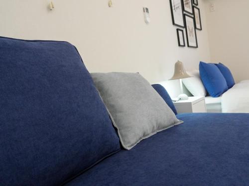 a blue bed with a pillow on top of it at OUCHI HOTEL Onaganishi in Hiroshima