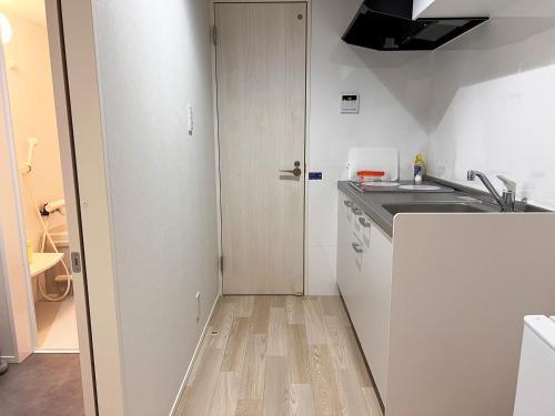 a small kitchen with a sink and a counter at OUCHI HOTEL Onaganishi in Hiroshima