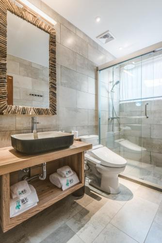 a bathroom with a sink and a toilet and a shower at Ron Inn Xingping Hepan Xiaozhu in Yangshuo