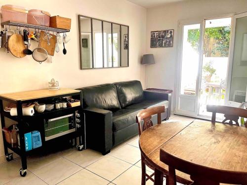 un salon avec un canapé en cuir noir et une table dans l'établissement Two rooms and large terrace, à Montpellier