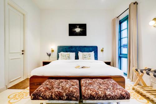 a bedroom with a large bed with a blue headboard at Valencia By DanCenter - 3 Bhk Villa in Siolim in Siolim