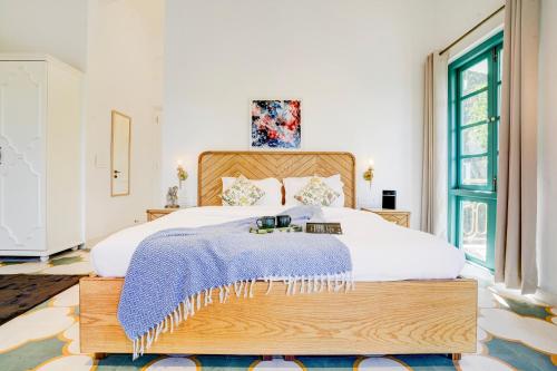 a bedroom with a large bed with a wooden headboard at Valencia By DanCenter - 3 Bhk Villa in Siolim in Siolim