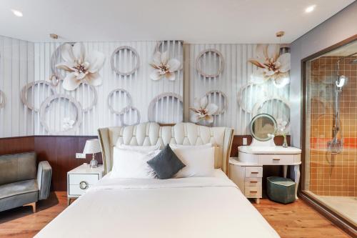a bedroom with a large white bed and a mirror at Apec Mandala Mũi Né Resorts & Hotels NN in Phan Thiet