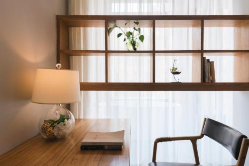 a desk with a lamp and a chair and a window at Ron Inn Xingping Hepan Xiaozhu in Yangshuo