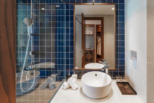 a bathroom with a sink and a shower and a tub at Apec Mandala Mũi Né Resorts & Hotels NN in Phan Thiet