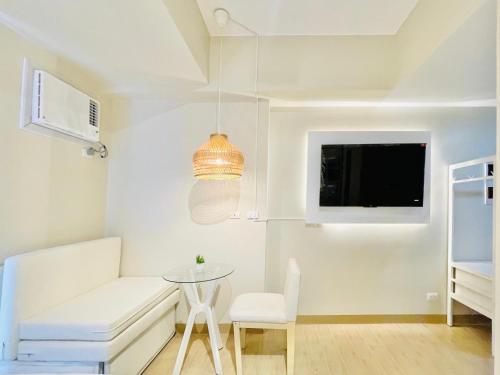 a living room with a white couch and a table at The Palladium Retreat in Iloilo City