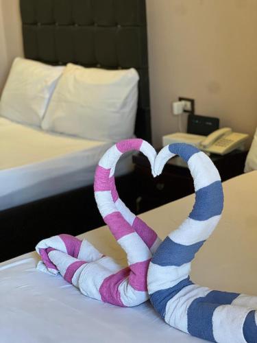 a pair of towels in the shape of a heart on a bed at La mer Hotel in Alexandria