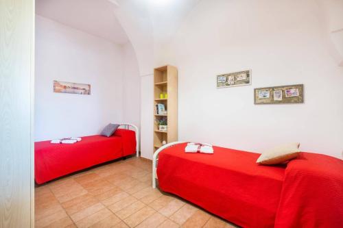 two beds in a room with red sheets at Villa Aranceto by Villa Plus in San Vito dei Normanni