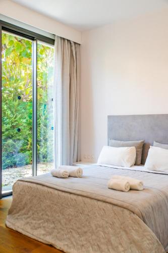 a bedroom with a large bed with two towels on it at Villa Laurus 2 by Ezoria Villas in Paphos