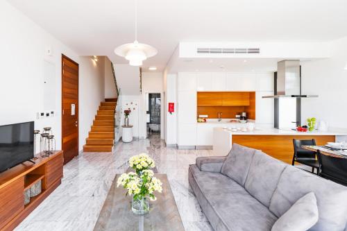 a living room and kitchen with a couch and a table at Villa Laurus 2 by Ezoria Villas in Paphos