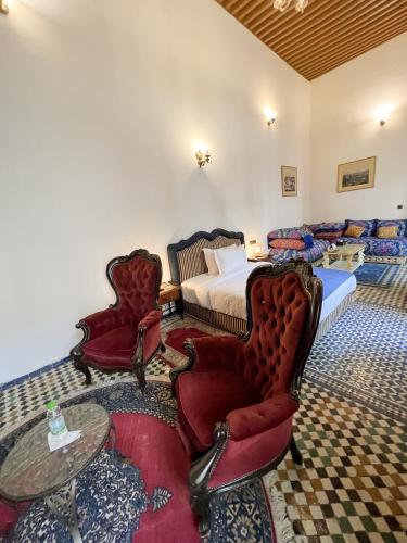 a bedroom with a bed and a table and chairs at Le Riad Palais d'hotes Suites & Spa Fes in Fès