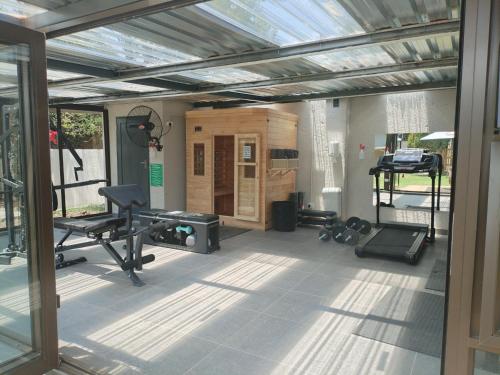 a gym with equipment in the middle of a room at Luyana guesthouse in Kroonstad
