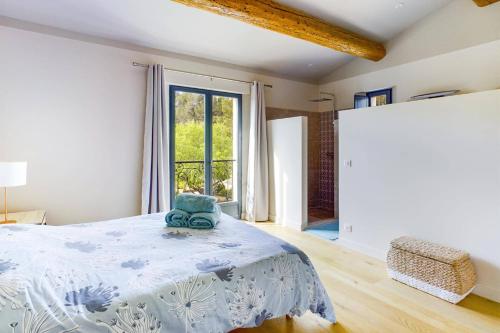 a bedroom with a bed and a large window at Villa Les Alpilles by Villa Plus in Mouriès