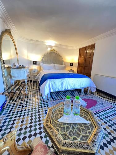 a bedroom with a bed and two water bottles on a table at Le Riad Palais d'hotes Suites & Spa Fes in Fès