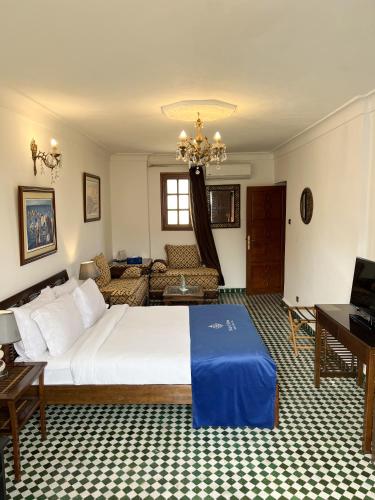 a bedroom with a large white bed and a couch at Le Riad Palais d'hotes Suites & Spa Fes in Fès