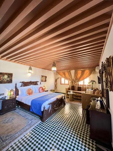 a bedroom with a large bed with a wooden ceiling at Le Riad Palais d'hotes Suites & Spa Fes in Fès