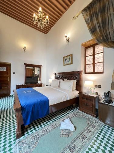 a bedroom with a large bed with a blue blanket at Le Riad Palais d'hotes Suites & Spa Fes in Fès