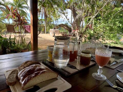 Fazenda Imagine Hospedaria في Entre Rios: طاولة خشبية عليها خبز وكأس من النبيذ