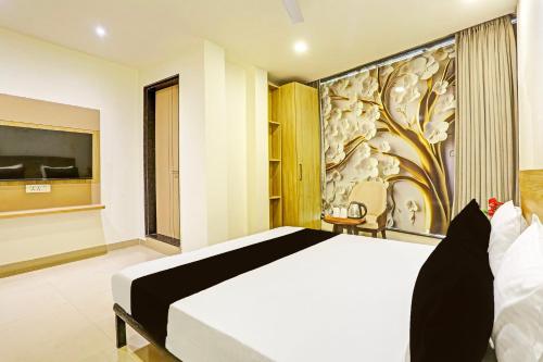 a bedroom with a bed and a painting on the wall at Super Hotel O Plush Homes in New Delhi