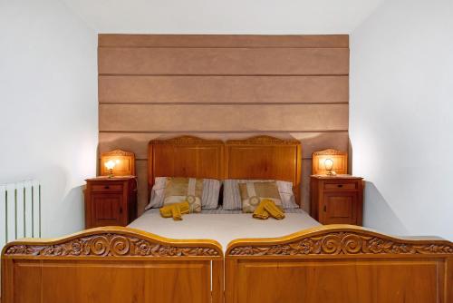une chambre avec un lit en bois avec deux oreillers jaunes dans l'établissement Appartamento Buthier Aosta, à Aoste