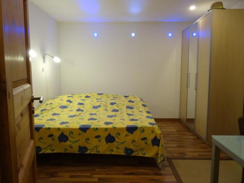 - une chambre avec un lit doté d'une couverture jaune et bleue dans l'établissement Vire de Vie, à Villiers